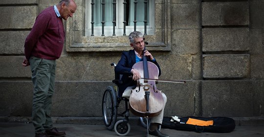 An injured orchestra cellist plays for pennies on the street